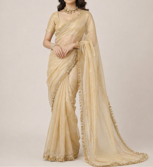 Woman wearing a beige saree with a plain background